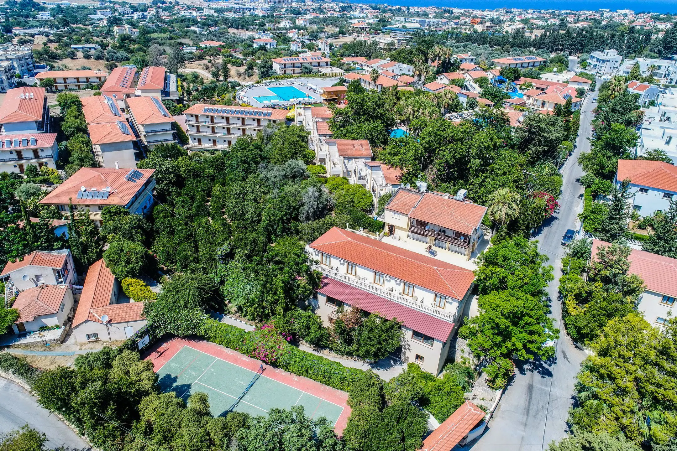 Luxury private taxi arriving at Riverside Garden Resort, an iconic holiday village in Alsancak, Kyrenia, featuring beautiful gardens and mountain views