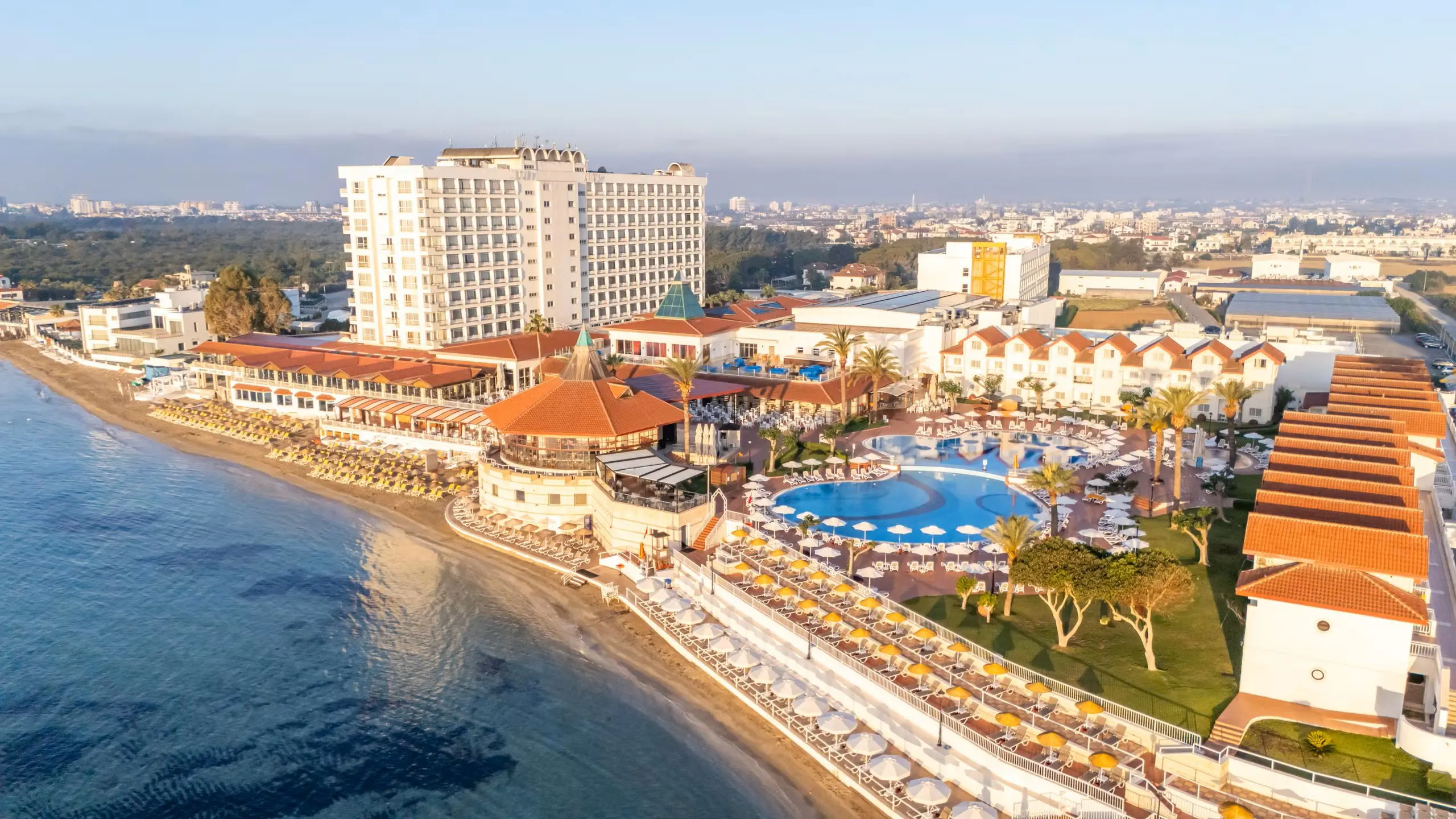 Private luxury taxi arriving at Salamis Bay Conti Resort, a 5-star all-inclusive beachfront hotel in Famagusta, North Cyprus, featuring a large pool and golden sand beach